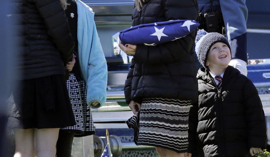 FILE - In this March 22, 2016 file photo, Reisa Clardy, the widow of Mass. State Trooper Thomas L. Clardy, holds a folded flag as she and her children watch balloons fly during his funeral in Hudson, Mass. As Massachusetts voters prepare to decide whether to legalize recreational marijuana use, the widow of a state trooper and father of seven killed when a driver high on marijuana barreled into his cruiser, is making an emotional plea against a ballot question that would legalize recreational marijuana. (AP Photo/Elise Amendola, File)