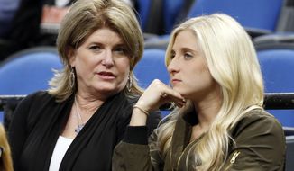 In this Oct. 21, 2016 photo, Debbie Saunders, left, and daughter Kim chat before the Minnesota Timberwolves NBA basketball game against the Charlotte Hornets in Minneapolis. It would have been easy for the Saunders family to walk away after late head coach Flip Saunders passed away last year. Instead, a year after he died, they have remained around the organization to try to help carry his legacy forward. Widow Debbie bought seats just behind the Timberwolves bench, daughter Rachel works in the Wolves front office and son Ryan is coaching with Tom Thibodeau as they try to build a winner in Minnesota. (AP Photo/Jim Mone)