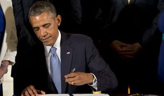 President Obama signs executive orders to protect LGBT employees from federal workplace discrimination in the East Room of the White House on July 21, 2014. (Associated Press) **FILE**