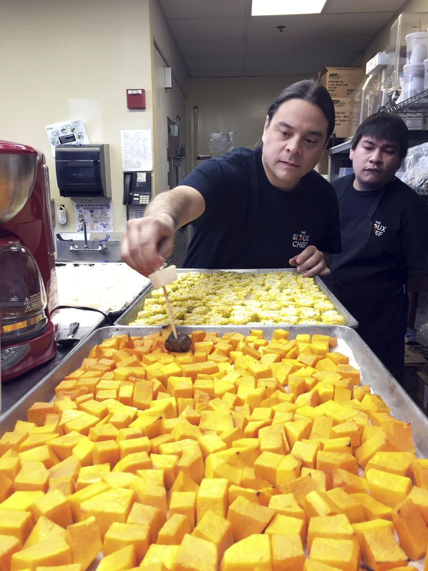 In this Oct. 24, 2016 photo, Sean Sherman shows one of his chefs how to skewer vegetables for an upcoming dinner for donors in Minneapolis. Sherman, an Oglala Lakota chef, embarked on a journey almost a decade ago to bring Native American cuisine to more tables. Thanks to the help of donors, he's now preparing to open his own restaurant in the Minneapolis area, with a focus on getting back to sustainable, organic foods from the region which Native Americans hunted and gathered before unhealthy processed foods were introduced to their diet. (AP Photo/Amy Forliti)