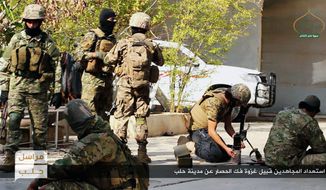 This photo released online on Friday, Oct. 28, 2016, by the website of the al Qaeda-linked Fatah al-Sham, an anti-government militant group, shows fighters from the al Qaeda-linked Fatah al-Sham Front preparing for the offensive on government positions in the northern Syrian province of Aleppo. Fierce fighting broke out around the northern Syrian city of Aleppo Friday as rebels announced a large-scale offensive to break the government&#39;s nearly two-month siege of opposition-held areas. Arabic, bottom, reads: &quot;Holy warriors getting ready for the battle to break the siege of Aleppo.&quot; (militant photo via AP)