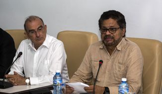 Humberto de La Calle, left, head of Colombia&#39;s government peace negotiation team, listens as Ivan Marquez, chief negotiator of the Revolutionary Armed Forces of Colombia (FARC) reads a joint statement in Havana, Cuba, Friday, Oct. 28, 2016. The statement said many new proposals have been incorporated in the text of a new peace accord after voters narrowly defeated the deal on Oct. 2.  (AP Photo/Desmond Boylan)