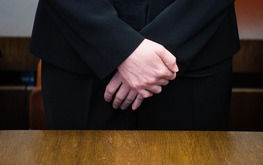 Defendant midwife, only identified as Regina K., stands on trial at the state court in Munich, southern Germany, Friday, Oct. 28, 2016. The court has convicted her on seven counts of attempted murder and sentenced her to 15 years in prison for secretly giving blood thinners to women shortly before they were to give birth by cesarean section. (Matthias Balk/dpa via AP)