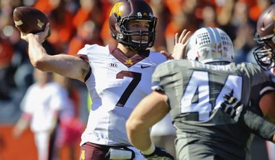 In this Oct. 25, 2014, photo, Minnesota quarterback Mitch Leidner (7) throws the ball while under pressure from Illinois defensive lineman Austin Teitsma (44) during an NCAA football game at Memorial Stadium in Champaign, Ill.  In a rebuilding season for Illinois, even the homecoming opponent is coming to town with a winning record and payback on its mind. In 2014 the Illini upset a Golden Gophers team that competing for a Big Ten West title, winning 28-24 on a late touchdown. Minnesota quarterback Mitch Leidner says it was one of the first things coach Tracy Claeys stressed this week. (AP Photo/Bradley Leeb)