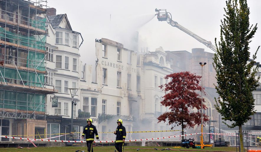 Firefighters continue to tackle the blaze at the badly damaged The Royal Clarence Hotel, in Exeter, England, Saturday, Oct. 29, 2016. A fire has severely damaged what is thought to be England's oldest hotel. The blaze in the southwestern city of Exeter raced through the historic Royal Clarence Hotel, which overlooks the city's medieval cathedral. Firefighters were still tackling the blaze on Saturday, a day after it broke out. The hotel, which had been operating under the name Abode Exeter, dates to 1769. (Ben Birchall/PA via AP)