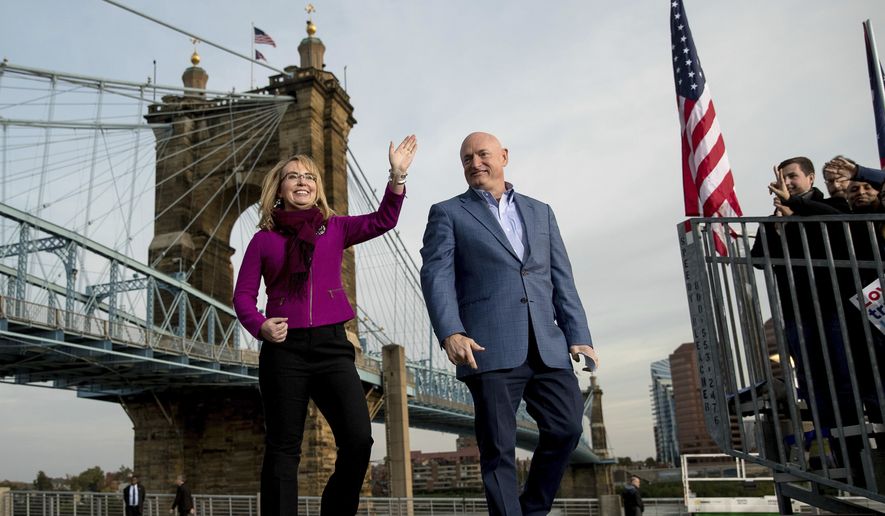 Gabby Giffords and her husband Mark Kelly, take the stage for a rally for Democratic presidential candidate Hillary Clinton at Smale Riverfront Park in Cincinnati, Monday, Oct. 31, 2016. (AP Photo/Andrew Harnik)