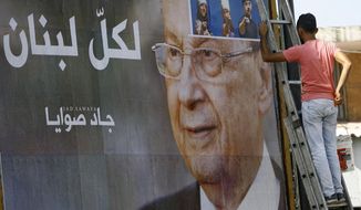 A worker hangs a billboard showing Christian leader Michel Aoun with Arabic that reads &amp;quot;For all Lebanon,&amp;quot; in the southern port city of Sidon, Lebanon, Sunday, Oct. 30, 2016. Aoun, an 81-year-old veteran Christian politician, is set to be elected by Parliament on Monday as part of a political deal that&#39;s expected to be another boost for President Bashar Assad in neighboring Syria. (AP Photo/Mohammed Zaatari)