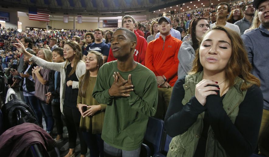 In this Wednesday, Oct. 12, 2016 photo, Liberty University students sing and pray prior to a speech by Republican vice presidential candidate, Indiana Gov. Mike Pence, at Liberty University in Lynchburg, Va. Evangelicals, deeply divided over Republican presidential candidate Donald Trump, are wrestling with what the tumultuous 2016 election will mean for their future. (AP Photo/Steve Helber/File)
