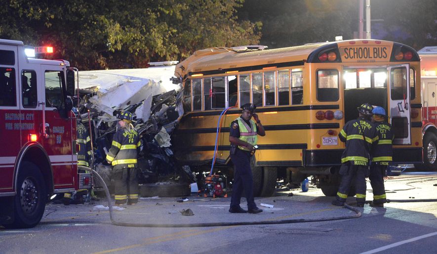 Fire department and rescue officials are at the scene of an early morning fatal collision between a school bus and a commuter bus Tuesday, Nov. 1, 2016, in Baltimore. (Jeffrey F. Bill/Baltimore Sun via AP)