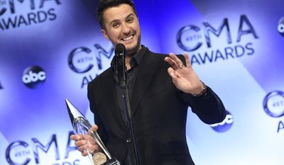 FILE - In this Nov. 4, 2015 file photo, Luke Bryan, winner of the award for entertainer of the year, poses in the press room at the 49th annual CMA Awards in Nashville, Tenn.  Bryan is again nominated for entertainer of the year at the Country Music Association Awards on Wednesday, Nov. 2, an award he won the last two consecutive years. (Photo by Evan Agostini/Invision/AP, File)