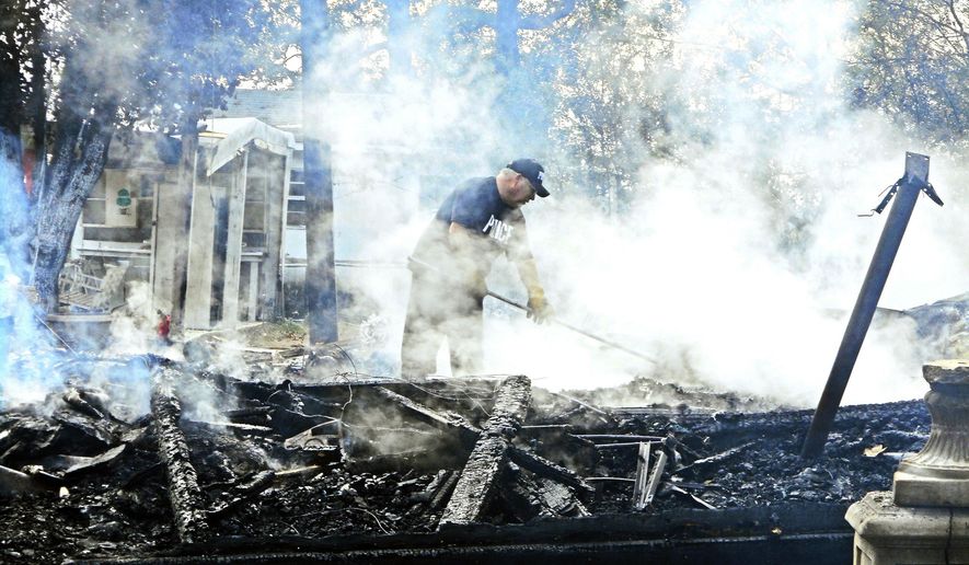 Officials search through rubble of a house fire that claimed the lives of three young children Wednesday, Nov. 2, 2016, in Cash, Ark. One adult was also seriously injured in the fire early Wednesday in Cash, about 100 miles northeast of Little Rock. (Jeff Bricker/The Jonesboro Sun via AP)