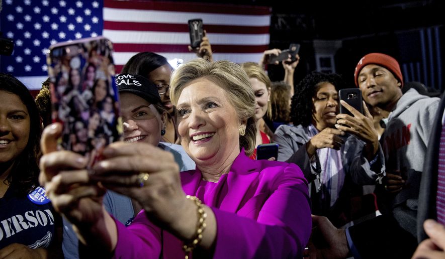 Democratic presidential candidate Hillary Clinton, left, and performer Pharrell Williams, right, greets members of the audience after speaking at a rally at Coastal Credit Union Music Park at Walnut Creek in Raleigh, N.C., Thursday, Nov. 3, 2016. (AP Photo/Andrew Harnik)
