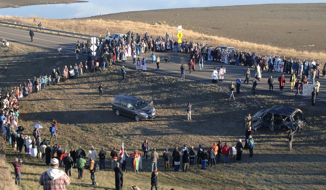 A giant prayer circle is formed to the south of the Backwater Bridge and Highway 1806 as hundreds of clergy of numerous denominations and faiths show support for Dakota Access Pipeline protesters, Thursday, Nov. 3, 2016 in Morton County, N.D. (Mike McCleary/The Bismarck Tribune via AP)