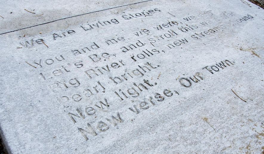 This Nov. 2, 2016 photo shows the poem "We are Living Stories," by Brenda Hughes, which was stamped into fresh concrete, marking a new arts effort to promote the arts in the community, near the corner of Harrison Street and Lincoln Boulevard, in Muscatine, Iowa. (Beth Van Zandt/Muscatine Journal via AP)