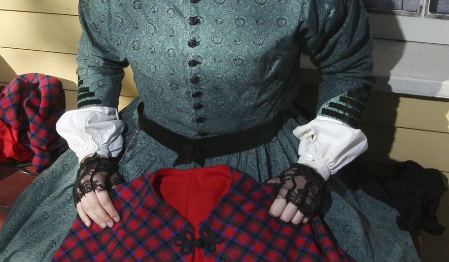 ADVANCE FOR USE SATURDAY, NOV. 5, 2016 AND THEREAFTER - In this Oct. 10, 2016 photo, Rachel Crowther models a Civil War period dress replica, while showing a Civil War period cape replica that she also sewed. Crowther has developed the skills to make historically accurate vintage clothing. (Jim Bowling/Herald & Review via AP)