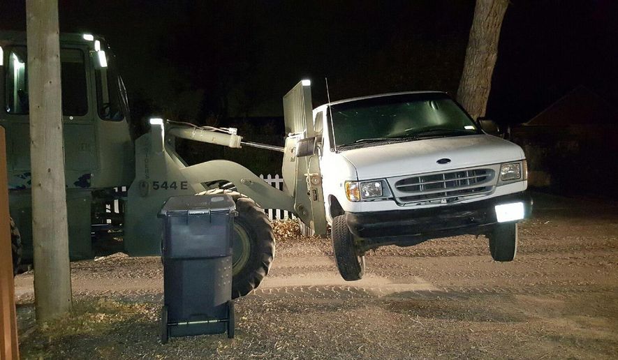 This Sunday, Oct. 30, 2016, photo taken by the Cheyenne Police Department , shows a front-end loader with forklift that was used by a Cheyenne, Wyo., woman to move her van in front of her driveway. Neighbors called police late Saturday night and reported seeing the woman drinking beer while operating the loader. Police charged the woman, Ashley Basich, of Cheyenne, with DUI. Basich has posted $950 bail and awaits a court appearance on Nov. 21. (Cheyenne Police Department)