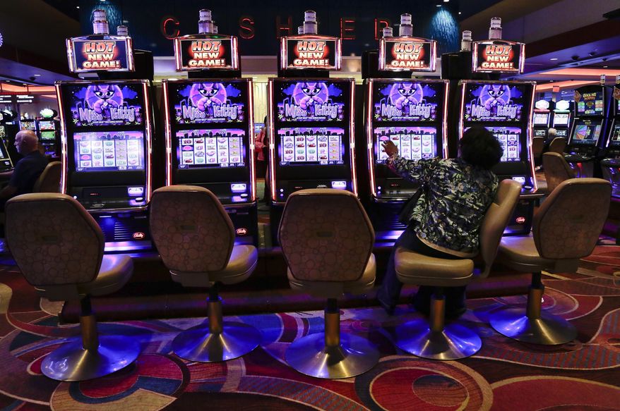 FILE - In this Oct. 3, 2014, file photo, a visitor to the Resorts World Casino at the Aqueduct racetrack plays an electronic slot machine, in the Queens borough of New York. The casino said on Nov. 3, 2016, that a woman who was shown that she won nearly $43 million on a penny slot in August 2016 actually won $2.25. (AP Photo/Julie Jacobson, File)