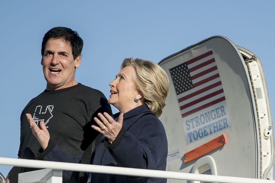 Democratic presidential candidate Hillary Clinton, accompanied by Dallas Mavericks basketball team owner Mark Cuban, arrives at Detroit Metropolitan Airport in Detroit, Friday, Nov. 4, 2016, to attend a rally. (AP Photo/Andrew Harnik)