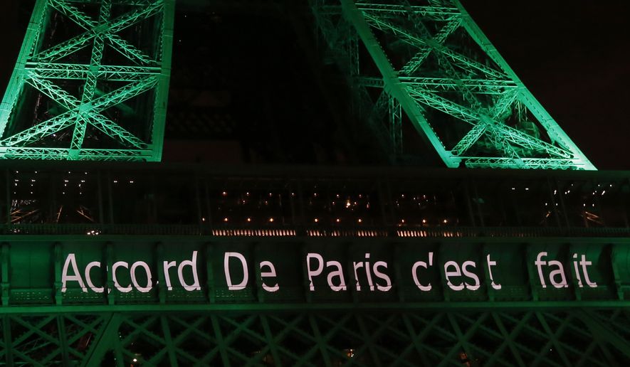 The Eiffel Tower lit up in green to mark the success of the Paris Agreement, Friday Nov.4, 2016 in Paris. The Paris Agreement on climate change enters into force Friday faster than anyone had anticipated, after a year with remarkable success in international efforts to slash man-made emissions of carbon dioxide and other global warming gases. Inscription reads, &quot;Paris Agreement it&#39;s done&quot;.(AP Photo/Michel Euler)