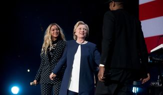 Democratic presidential candidate Hillary Clinton, center, is welcomed to the stage by artists Jay Z, right, and Beyonce, left, during a free concert at at the Wolstein Center in Cleveland, Friday, Nov. 4, 2016. (AP Photo/Andrew Harnik)