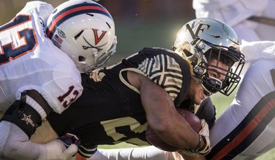 Wake Forest sophomore running back Matt Colburn (22) is tackled after a run by Virginia sophomore outside linebacker Chris Peace (13) during an NCAA college football game, Saturday, Nov. 5, 2016 in Winston-Salem, N.C. (Andrew Dye/The Winston-Salem Journal via AP)