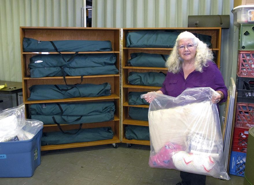 In this Tuesday, Nov. 1, 2016 photo, Judi Joy, shelter manager at the Good Samaritan Haven shows cots and linens to be used at an overflow seasonal shelter for men that opened in a church this week in Barre, Vt. Vermont continues to make investments in emergency community housing for the homeless. (AP Photo/Lisa Rathke)