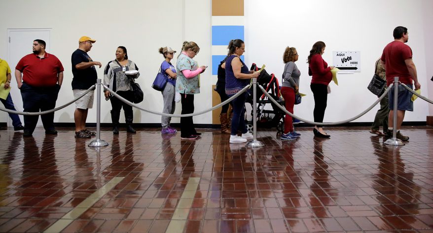 Voters wait in line to cast ballots at an early polling site in Texas. As of this weekend, 41 million ballots have already been cast. (Associated Press)