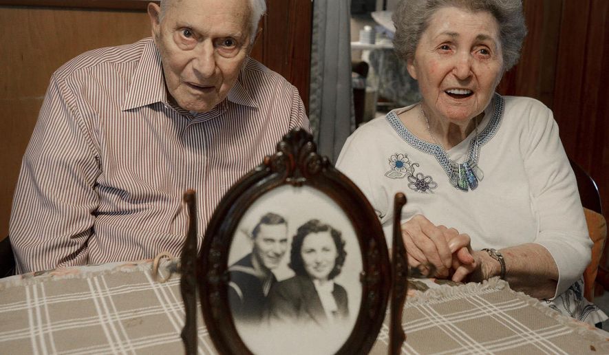 In this Oct. 21, 2016 photo, Philip and Dorothy Dougan pose as a photo sits on the table in front of them at their home in Madison County, Tenn. They are celebrating their 75th wedding anniversary. (Kenneth Cummings/The Jackson Sun via AP)