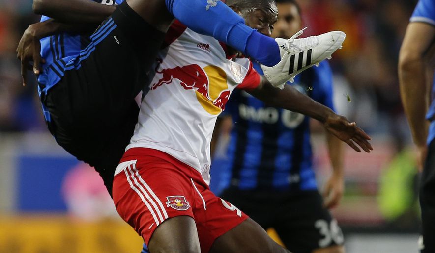 Montreal Impact defender Hassoun Camara, left, goes over the back of New York Red Bulls forward Bradley Wright-Phillips for the ball in the first half during an MLS Eastern Conference Semifinal soccer match at Red Bull Arena in Harrison, N.J., Sunday, Nov. 6, 2016. (AP Photo/Rich Schultz)