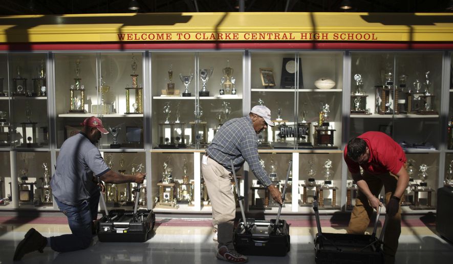 Members of the Athens-Clarke County Board of Elections and members of the Athens-Clarke County Facilities Management set up voting machines at Clarke Central High School in Athens, Ga., Monday, November 07, 2016. (John Roark/Athens Banner-Herald via AP)