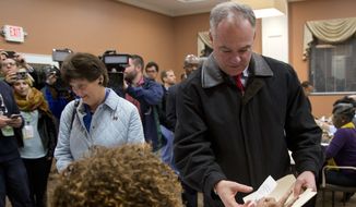 Democratic vice presidential candidate US Sen. Tim Kaine, D-Va., right, receives his ballot from a poll worker as he and his wife, Anne Holton vote in Richmond, Va., Tuesday, Nov. 8, 2016. (AP Photo/Steve Helber)