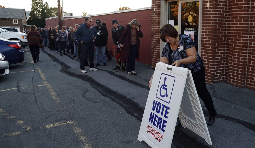 An election official places a sign as voters line up outside a polling place at the Fogelsville Volunteer Fire Co., Tuesday, Nov. 8, 2016, in Fogelsville, Pa. (AP Photo/Matt Slocum) ** FILE **