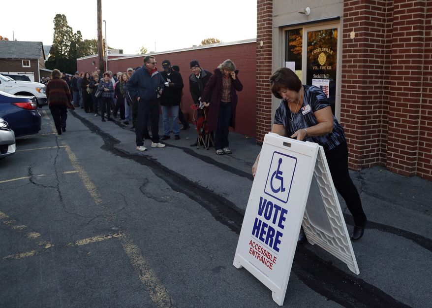 An election official places a sign as voters line up outside a polling place at the Fogelsville Volunteer Fire Co., Tuesday, Nov. 8, 2016, in Fogelsville, Pa. (AP Photo/Matt Slocum) ** FILE **