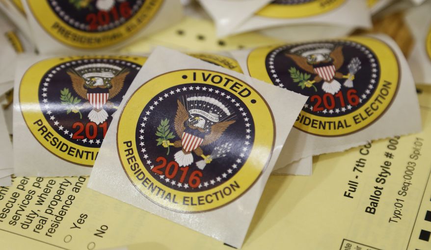 I voted stickers rest on a sample ballot ready for voters at a polling place in Richmond, Va., Tuesday, Nov. 8, 2016. (AP Photo/Steve Helber)
