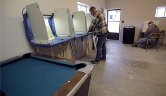 John Wilson, left, from Bear Creek, Mo., and Russell Madison, from Humansville, Mo., vote in a game room on a family farm Tuesday, Nov. 8, 2016 near Humansville, Mo. (AP Photo/Charlie Riedel)