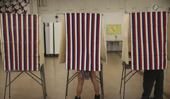 Voters cast their ballots in booths at Farrington High School, Tuesday, Nov. 8, 2016, in Honolulu. (AP Photo/Marco Garcia) **FILE**