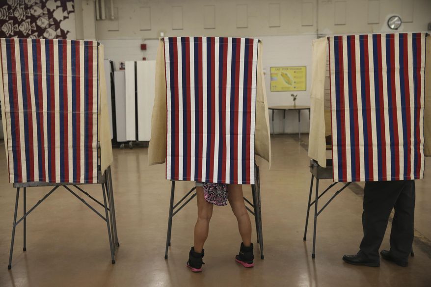 Voters cast their ballots in booths at Farrington High School, Tuesday, Nov. 8, 2016, in Honolulu. (AP Photo/Marco Garcia) **FILE**