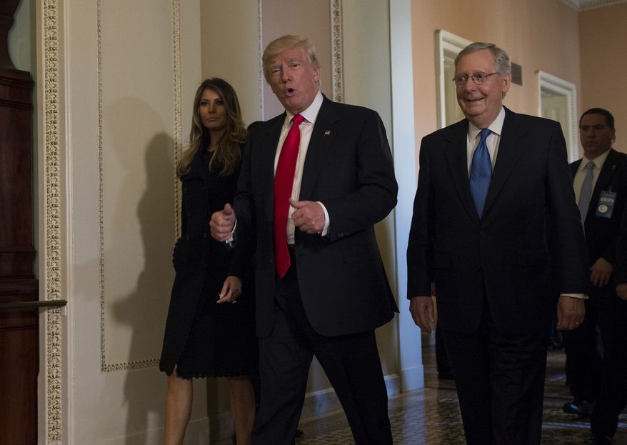 President-elect Donald Trump, accompanied by his wife Melania, and Senate Majority Leader Mitch McConnell of Ky., gestures while walking on Capitol Hill in Washington, Thursday, Nov. 10, 2016, after meeting.  (AP Photo/Molly Riley)