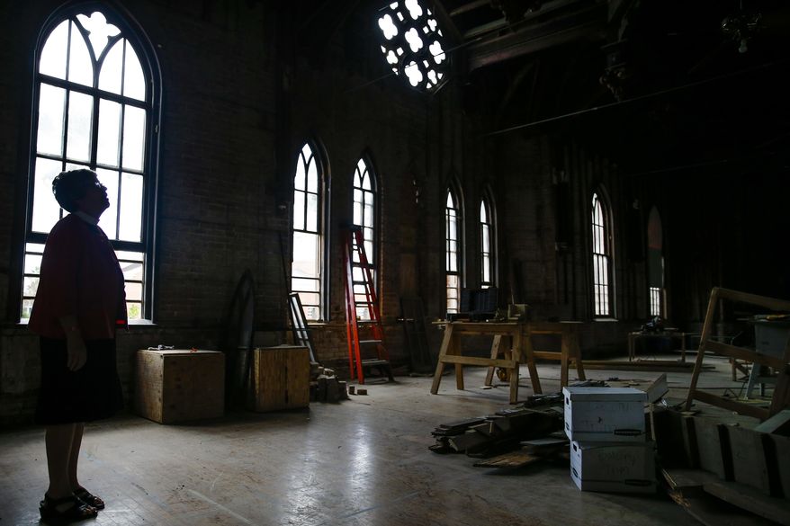 ADVANCE FOR SUNDAY NOV. 13 AND THEREAFTER - In a Oct. 11, 2016 photo, Trinity Episcopal Church Rev.Susan Kennard looks up at the restoration work being done to the 1870s-era Eaton Chapel to save the space, which was designed by famed architect Nicholas Clayton, in Galveston. ( Michael Ciaglo/Houston Chronicle via AP)