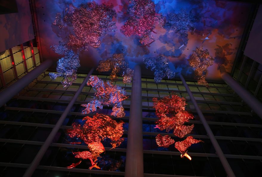 Artist Ed Wilson's new sculpture, "Soaring in the Clouds," is displayed inside the new grand lobby of the George R. Brown Convention Center in downtown Houston, Thursday, Nov. 10, 2016. The sculpture is made of many small pieces suspended from the almost 100-foot-high ceiling and lit by constantly changing colors. (Mark Mulligan/Houston Chronicle via AP)