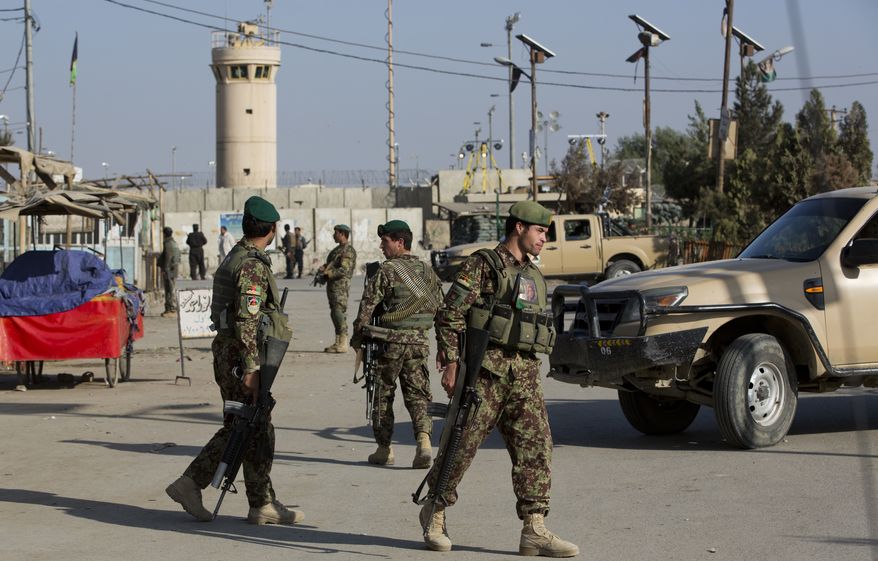 Afghanistan's National Army soldiers guard, blocking the main road to the Bagram Airfield's main gate in Bagram, north of Kabul, Afghanistan, Saturday, Nov. 12, 2016. An explosion at a U.S. airfield in Afghanistan early Saturday killed four people, the head of international forces in the country said. (AP Photos/Massoud Hossaini)