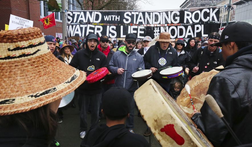 Led by the Sacred Water Canoe Family singing a warrior song, hundreds of demonstrators march west on Pacific Avenue in Tacoma, Wash. in support of the Standing Rock Sioux protest in North Dakota against DAPL, the oil pipeline, on Sat. Nov. 12, 2016.  (Alan Berner/The Seattle Times via AP)