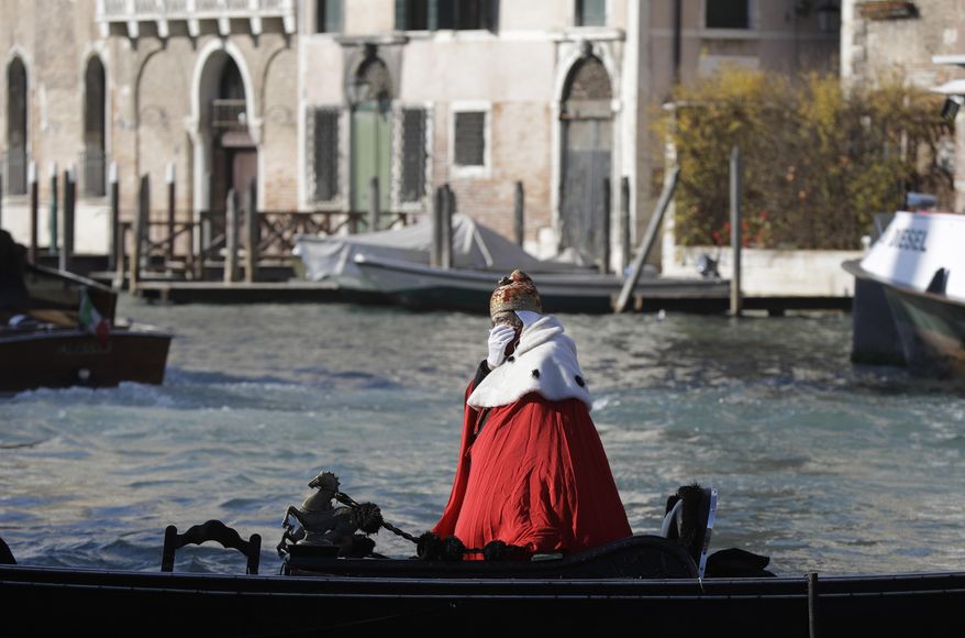 A protester on a gondola impersonates the "Doge of Venice" during a demonstration against the increasing number of tourists in Venice, Italy, Saturday, Nov.12. 2016. For decades, the number of Venetians have dwindled steadily and numerous factors are blamed _ high prices driven by a boom in tourism and the logistics of supplying a carless city and erosion by lapping waters among them. (AP Photo/Luca Bruno)