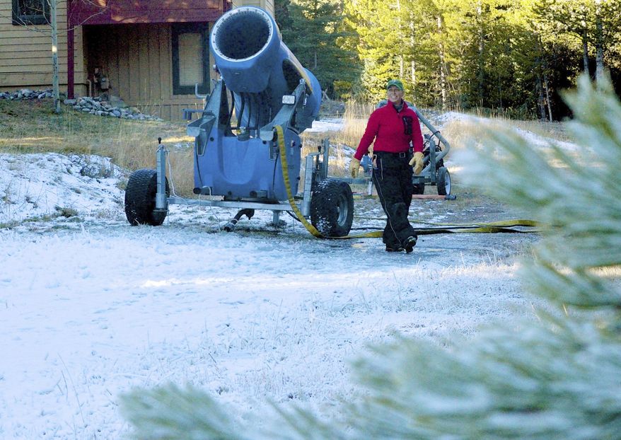 ADVANCE FOR SATURDAY, NOV. 12 - In this Friday, Nov. 4, 2016 photo, Michelle Vona, with the Breckenridge Nordic Center, checks a mobile snowmaking gun on a trail near the center's lodge near Breckenridge, Colo. Above-average temperatures have forced Colorado ski resorts to cut back on early-season snowmaking and, as a result, delay the openings of the resorts. (Phil Lindeman/Summit Daily News via AP)