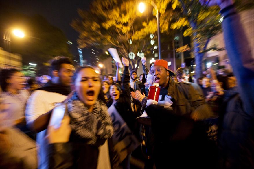 In this photo taken with a zoom effect, protesters march in the street to demonstrate against the election of President-elect Donald Trump in Atlanta, Friday, Nov. 11, 2016. Spurred by fear and outrage, protesters around the country rallied and marched Friday as they have done daily since Donald Trump's presidential election victory. (AP Photo/David Goldman)