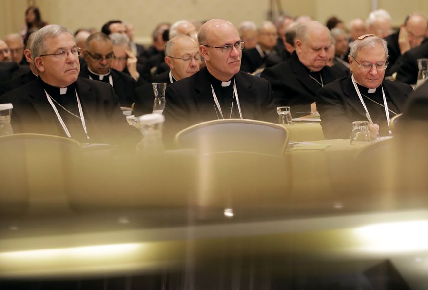 Members of the United States Conference of Catholic Bishops are seen above reflections on a piano as they attend the USCCB's annual fall meeting in Baltimore, Monday, Nov. 14, 2016. The bishops opened their meeting by urging President-elect Donald Trump to adopt humane policies toward immigrants and refugees. (AP Photo/Patrick Semansky)