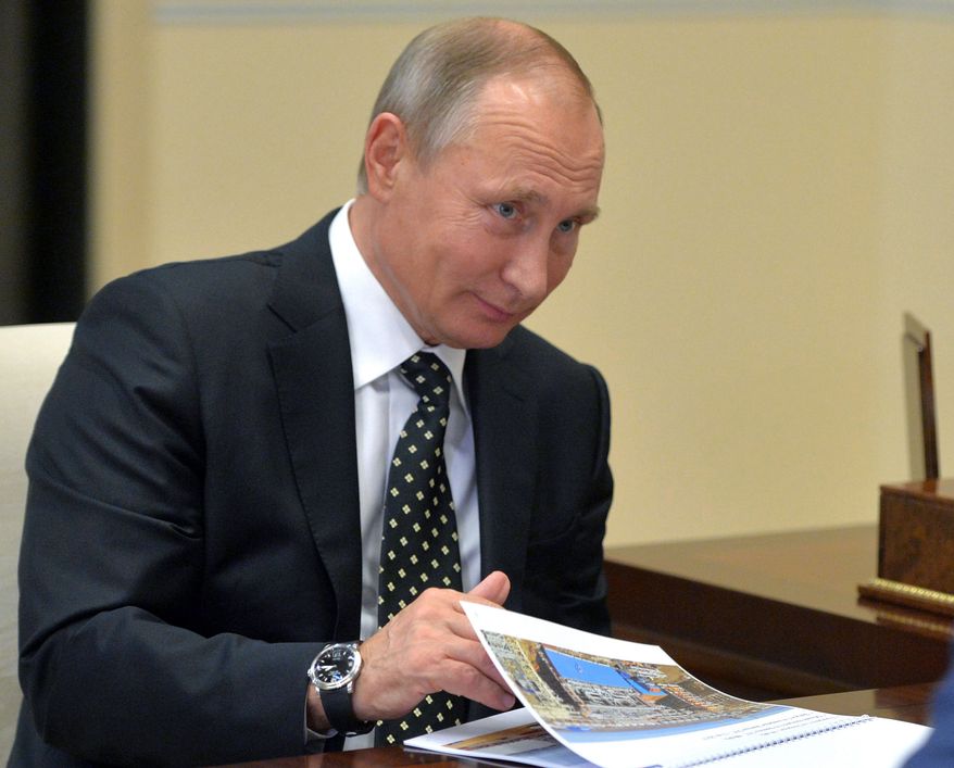 Russian President Vladimir Putin listens during a meeting in the Novo-Ogaryovo residence outside Moscow, Russia, on Monday, Nov. 14, 2016. (Alexei Druzhinin/Sputnik, Kremlin Pool Photo via AP)