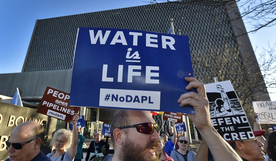 People including Steve Cramer, center, protest the Dakota Access pipeline project in front of the Richard Bolling Federal Building on Tuesday, Nov. 15, 2016, in downtown Kansas City, Mo. The company building a $3.8 billion oil pipeline sought a federal judge&#39;s permission Tuesday to circumvent President Barack Obama&#39;s administration and move ahead with a disputed section of the project in North Dakota, as opponents held protests across the country urging it to be rejected. (Keith Myers/The Kansas City Star via AP)