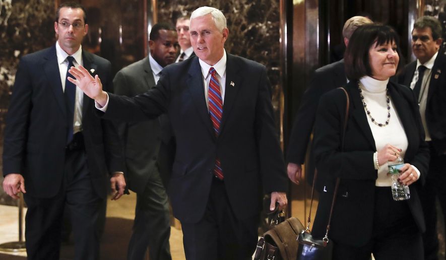 Vice President-elect Mike Pence waves to the media as he leaves Trump Tower with his wife Karen, Tuesday, Nov. 15, 2016, in New York. (AP Photo/Carolyn Kaster)
