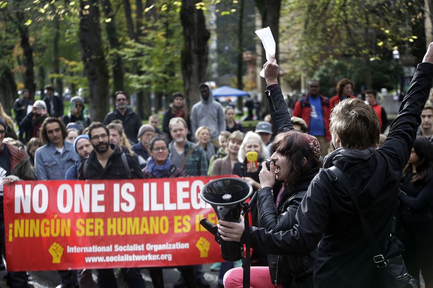 Protester Phoenix Singer, second from right, leads a chant before he and others march through the streets in Portland, Ore., Wednesday, Nov. 16, 2016. Approximately 100 students at Portland State University joined a nationwide campus walkout to protest President-elect Donald Trump. (AP Photo/Don Ryan)